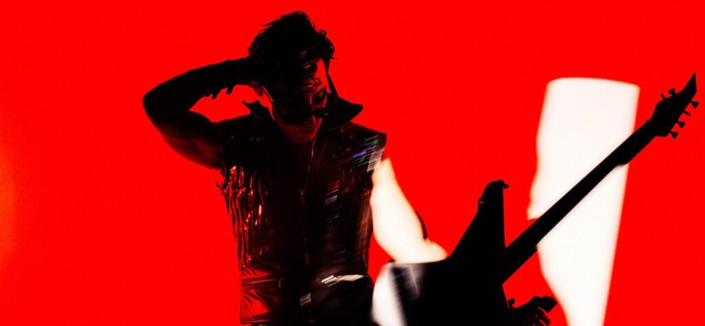 Silhouetted figure saluting against a vivid red background.