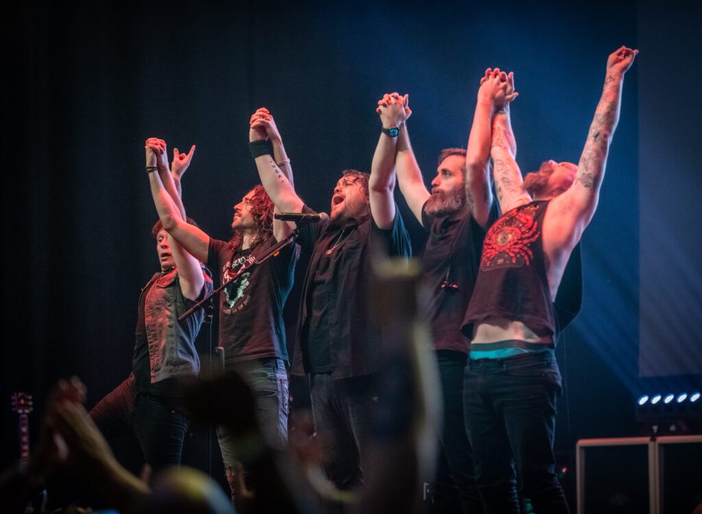 Band taking bow on stage after performance.