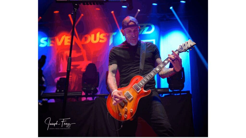 Guitarist with sunburst guitar under red lights