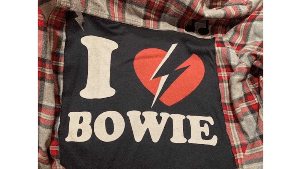 I Love Bowie" shirt on plaid fabric.