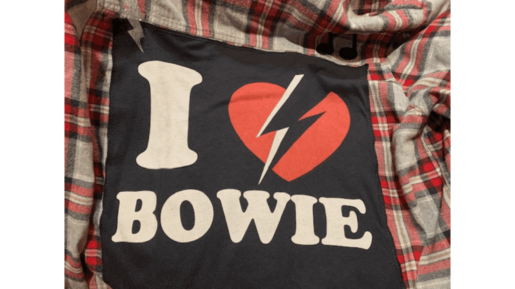 I Love Bowie" shirt on plaid fabric.