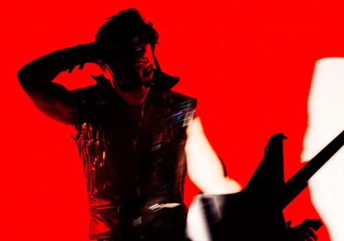 Silhouetted figure saluting against a vivid red background.