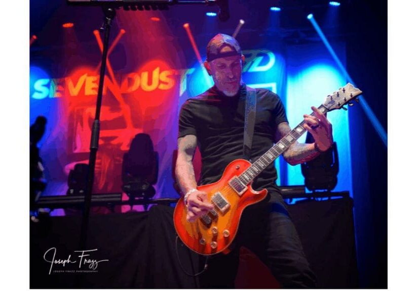 Guitarist with sunburst guitar under red lights