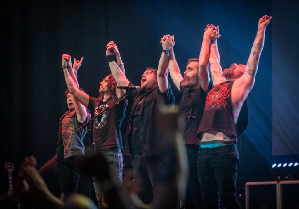 Band taking bow on stage after performance.