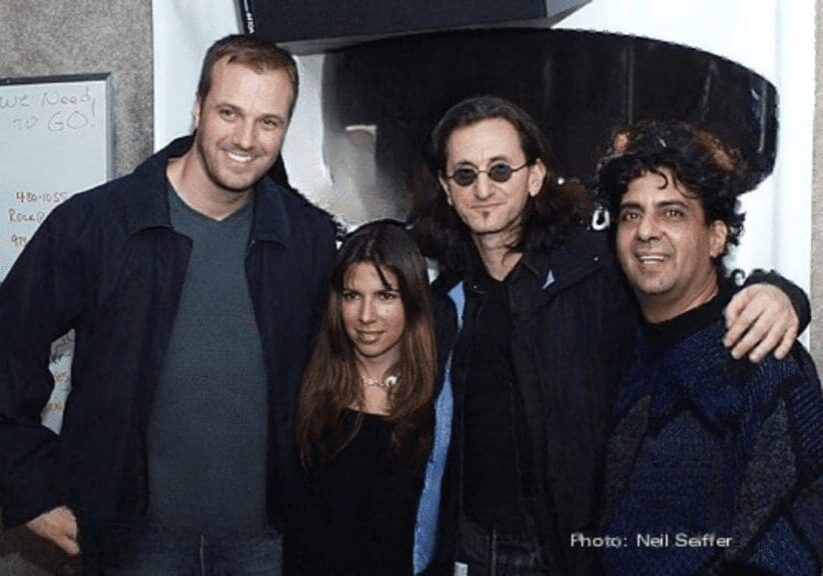 Four people posing together, casual setting.